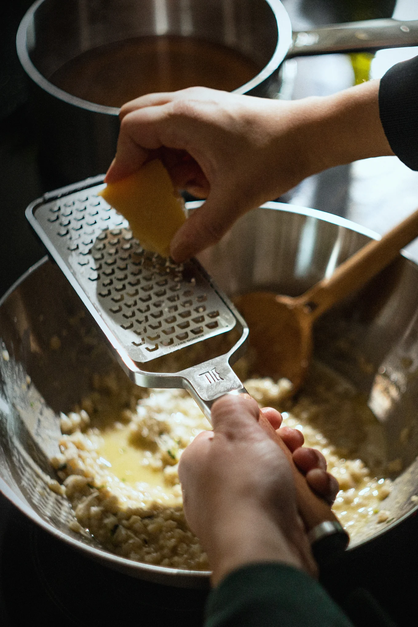 Parmesan rivs i en risotto med Norden-rivjärnet från Fiskars.