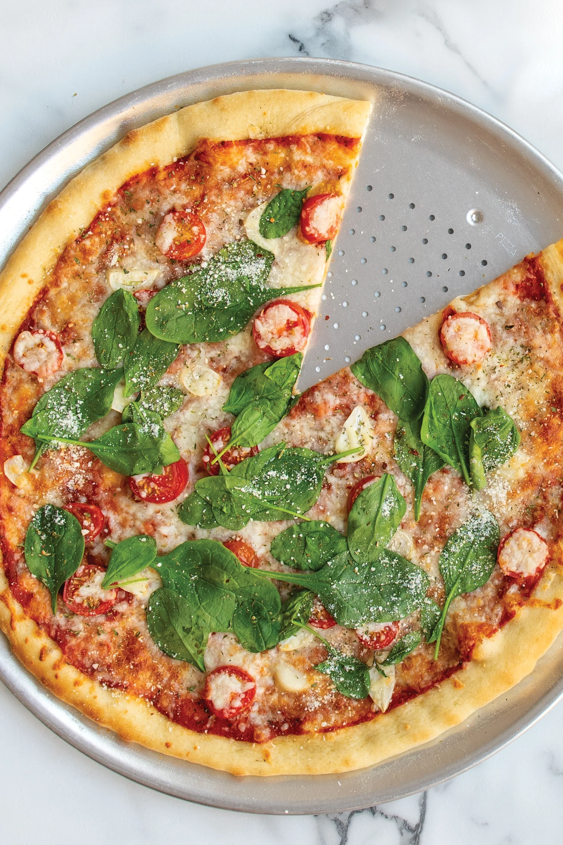 Du kan enkelt göra en vegansk pizza med hjälp av ersättningsprodukter. Den perforerade pizzabrickan från Nordic Ware är perfekt för att få en så krispig botten som möjligt.