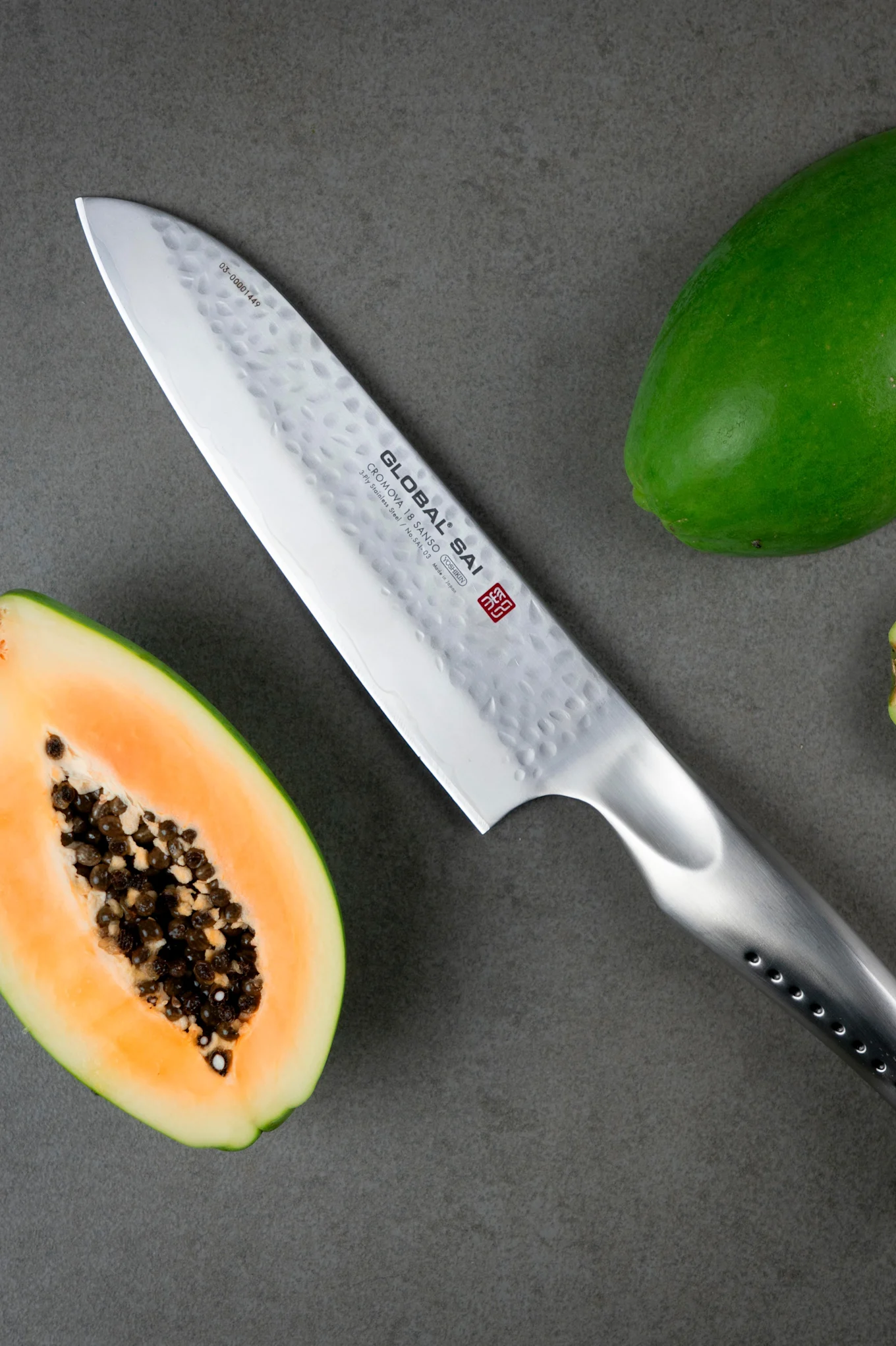 Global SAI-03 Santokukniv som tillhör Global knivserien SAI, med en halv melon bredvid.