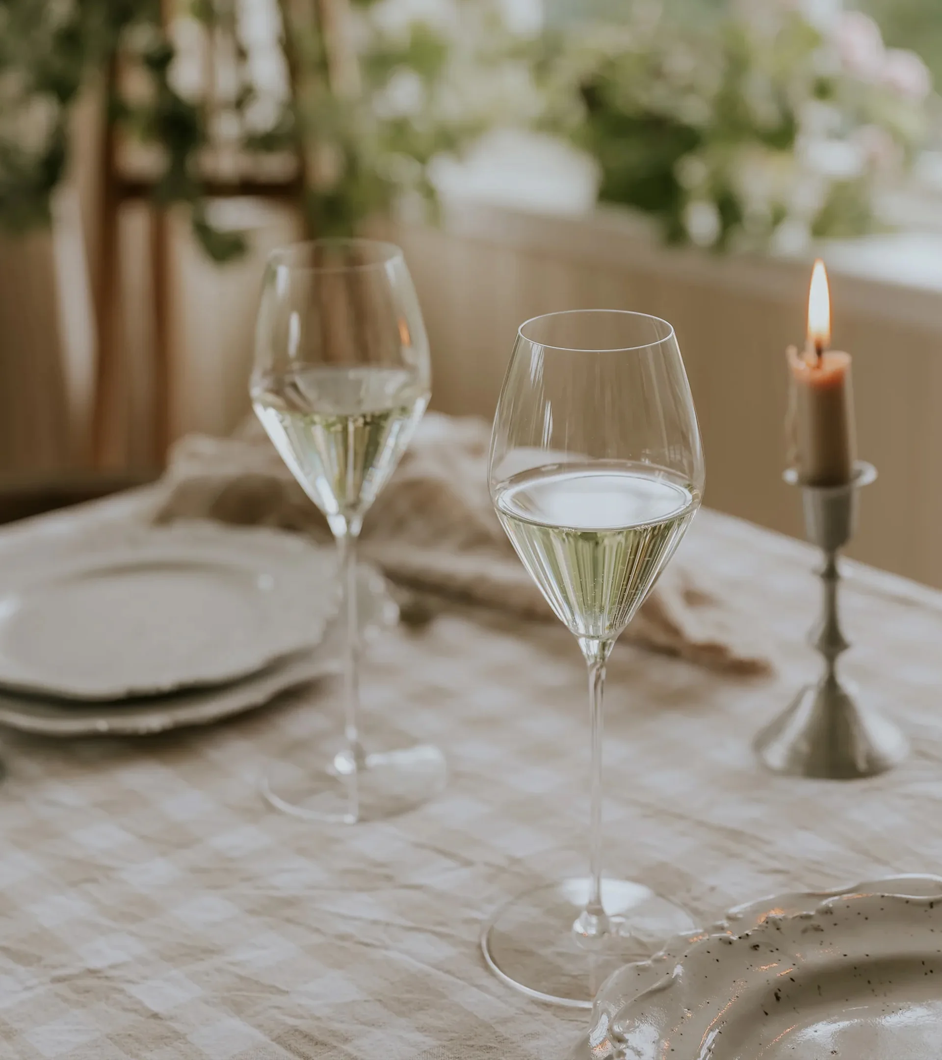 Ett klart vinglas fyllt till ungefär en tredjedel med rödvin, på en ljus yta mot en enfärgad ljus bakgrund.