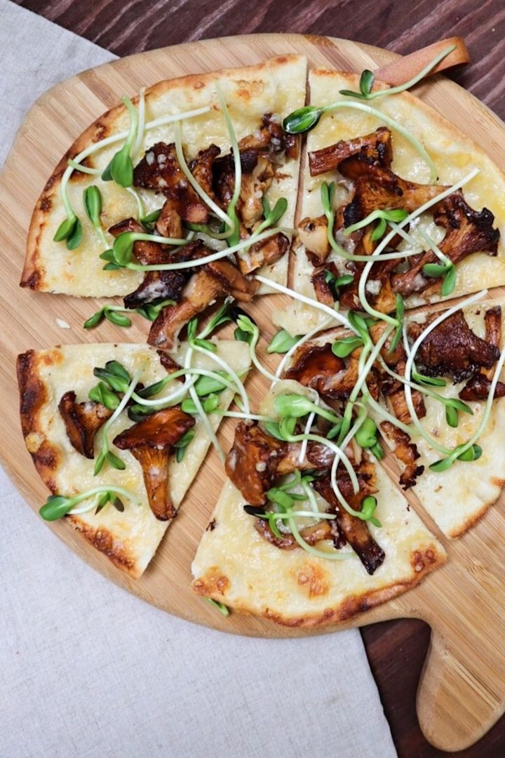 Kantarellpizza på skärbräda.