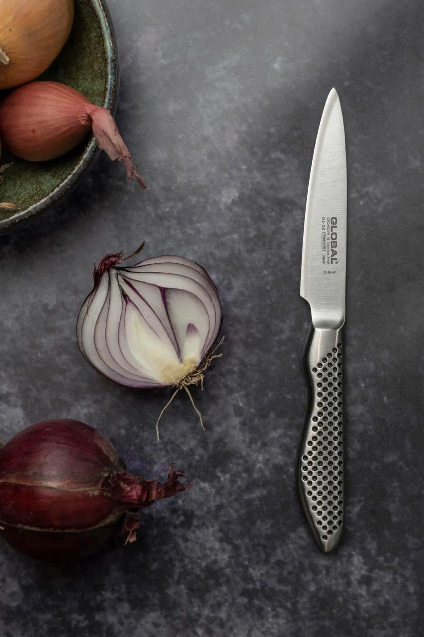 Global GS-38 skalkniv som tillhör Global knivserien Classic, med en rödlök bredvid.